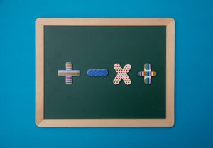 Green chalkboard with wooden frame, colorful math operation signs