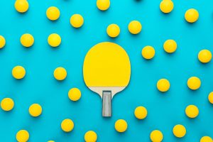 flat lay image of table tennis paddle and many balls central composition