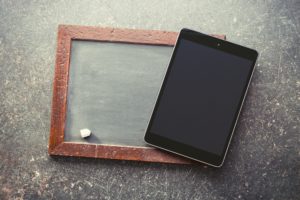 computer tablet and old chalkboard