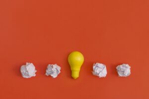 Paper and light bulb on yellow background. Idea concept