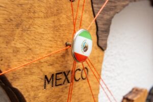 Mexico flag on the pin with red thread showed the paths on the wooden map.
