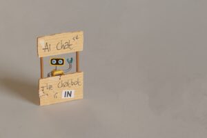 Yellow Toy Robot Manning AI Chat Stand