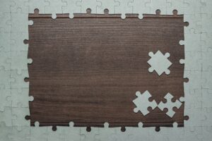 Frame Of Puzzle Pieces On Wooden Background