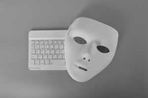 Laptop keyboard and anonymous mask. Data thief, internet fraud, cyberattack, cyber security concept.