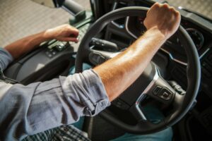 Truckers Hand on a Semi Truck Steering Wheel Close Up Photo