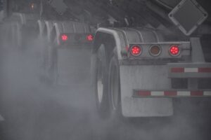 Wheels of tractor trailer driving on a highway during rain