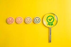 satisfaction with smiley face emoticon on wooden yellow background.