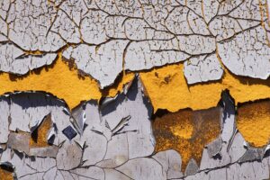 Detail of peeling and cracked paint on an old silo wall.