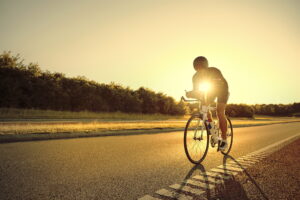 The athlete on bicycle on a road