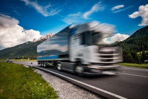 Fuel truck rushes down the highway in the background the Alps. Truck Car in motion blur.